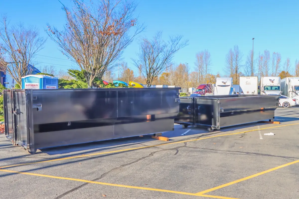 Professional dumpster rental service with roll-off container on residential driveway in Fair Lakes